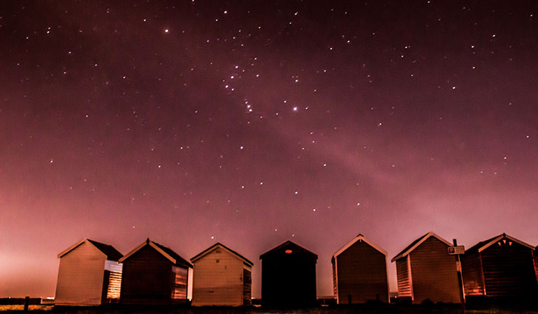 Stars above beach huts at Calshot Spit, New Forest