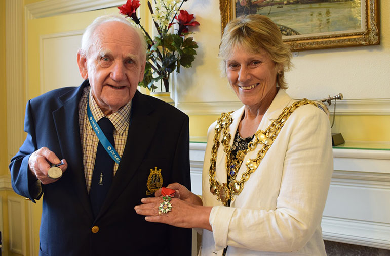 Lt Cdr Haskins Retired showing the Mayor of Poole, Cllr Xena Dion, his two medals of honour