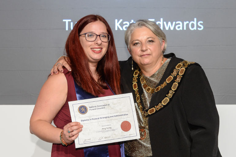 Amy being presented with her diploma by Kate Edwards, President of the National Association of Funeral Directors