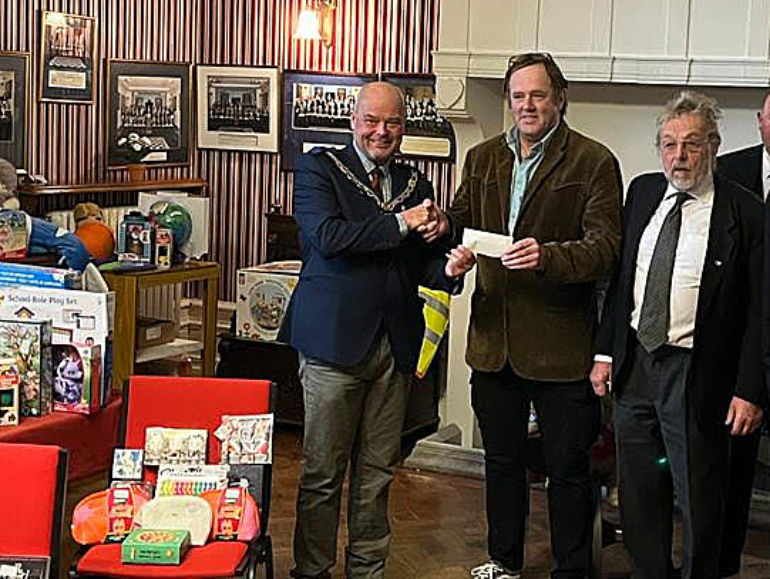 Leon Whitfield presents a cheque to Mr Scott Akam, co-founder the Dorset Children’s Foundation with Tony Drake looking on
