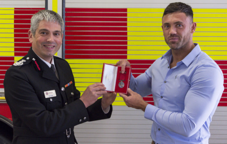 Luke receives the awards from chief fire officer Ben Ansell