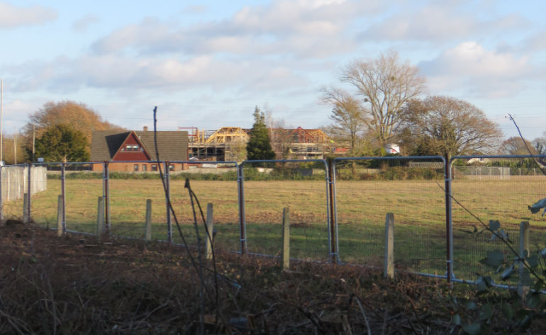 The face of West Parley could change forever. Looking from the Parley traffic lights across the field towards the care home development in the background © CatchBox2021