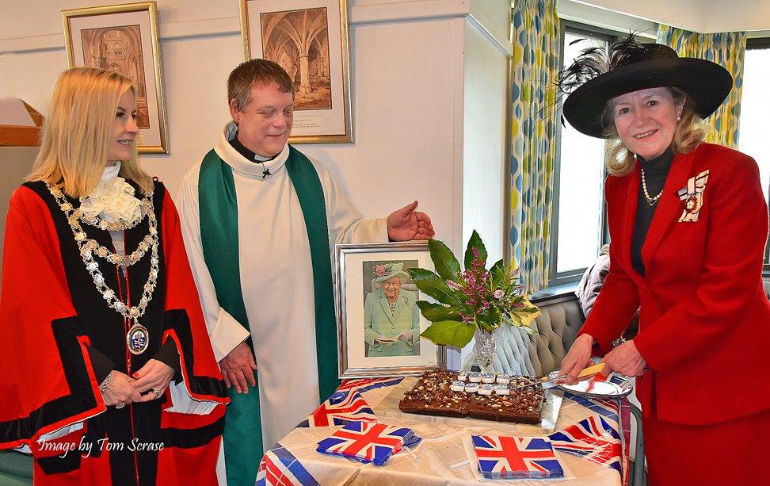 The Vice Lord-Lieutenant cuts the cake watched over by the mayor and the rector. Photo by Tom Scrase