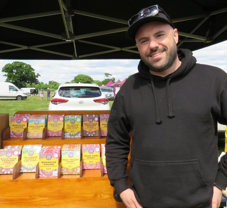Stallholder soaks up the atmosphere at the Cheese and Chilli Festival whilst selling his prepared curry mixes