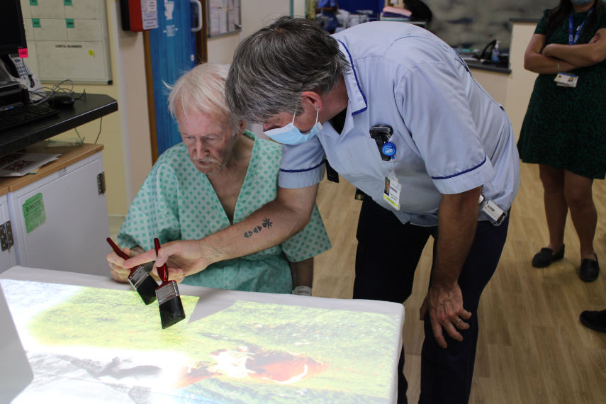 A patient painting a picture with the projector