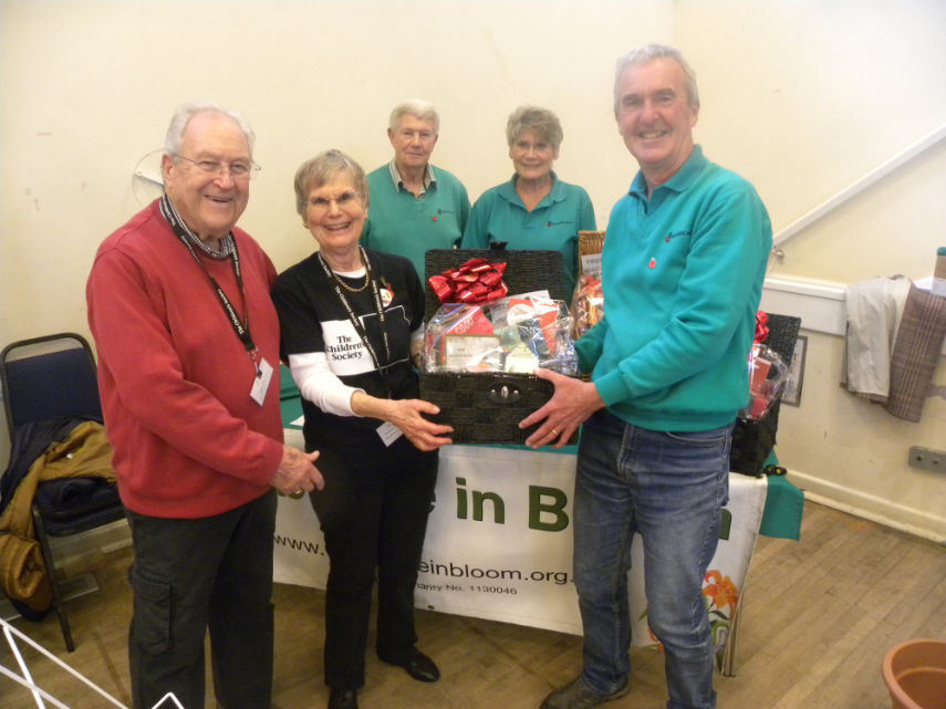 Rosemary Dunning, who was on the Children's Society Stall, receives the second prize hamper from John Allen who coordinated the fair on behalf of Wimborne in Bloom. Looking on is Rosemary's husband and Wimborne in Bloom committee members Chris and Jean Hooker. Photo by Anthony Oliver