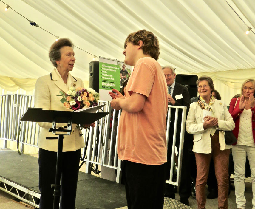 Student James Oswald presenting a posy of flowers to HRH The Princess Royal